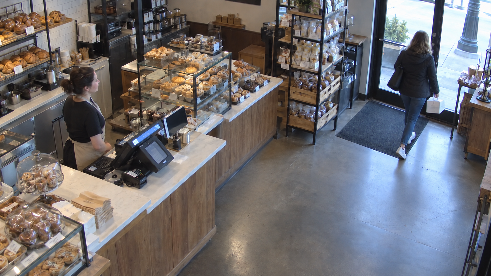 Simulated security camera view of a customer leaving the bakery with an unpaid order